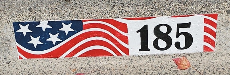 Decorated curb with painted address number — second example